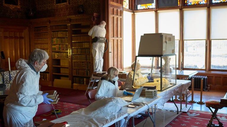 Volunteers caring for the extensive book collection at Charlecote Park, Warwickshire
